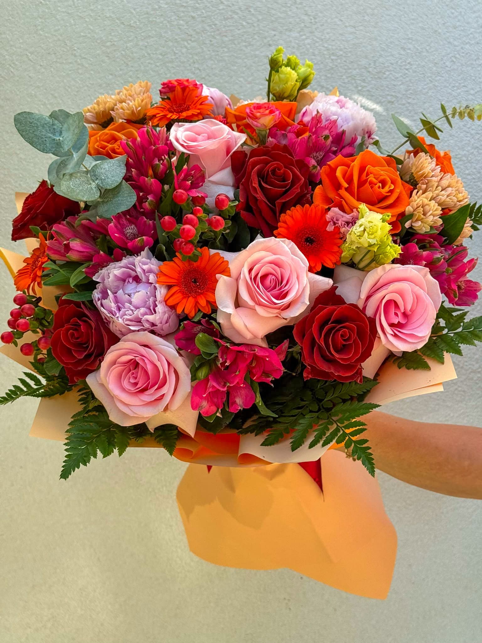 Buchet floral premium cu trandafiri roșii, roz și portocalii, gerbera vibrantă, hortensie mov și flori decorative de sezon. Un aranjament spectaculos, cu nuanțe intense și ambalaj elegant, ideal pentru aniversări, declarații de dragoste și ocazii speciale.