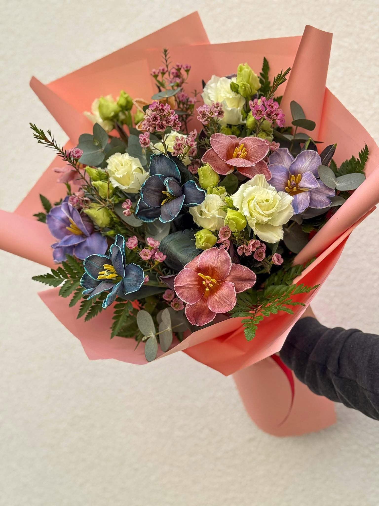 Buchet pastelat cu lalele colorate, lisianthus alb-verzui și waxflower roz, cu eucalipt și ferigă